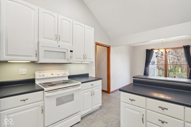 kitchen with white appliances, white cabinetry, and lofted ceiling