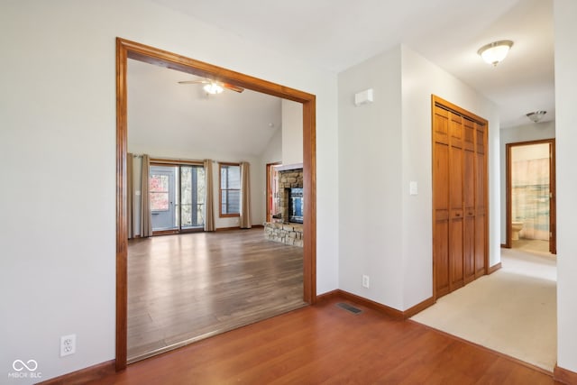 hallway featuring hardwood / wood-style flooring and vaulted ceiling