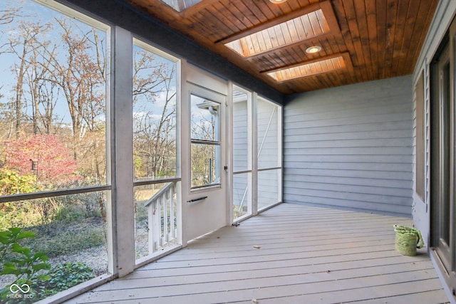 unfurnished sunroom featuring a skylight and wood ceiling