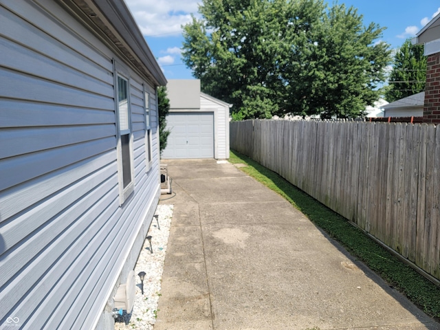 view of patio / terrace with a garage and an outbuilding