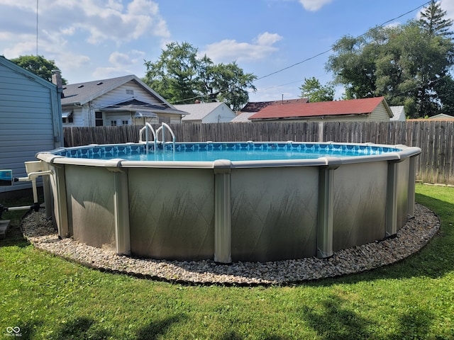 view of pool featuring a lawn