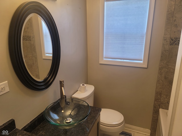 bathroom featuring tile patterned flooring, toilet, and vanity