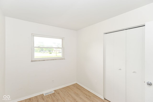 unfurnished bedroom with a closet and light wood-type flooring