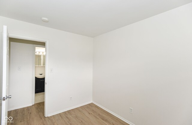 unfurnished room with light hardwood / wood-style flooring and sink