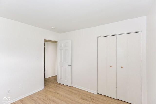 unfurnished bedroom featuring a closet and light wood-type flooring