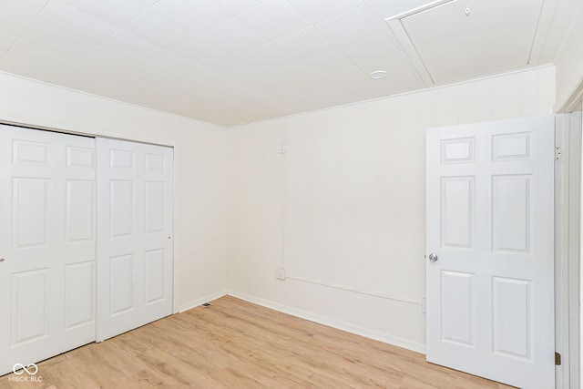 unfurnished bedroom with a closet and light wood-type flooring