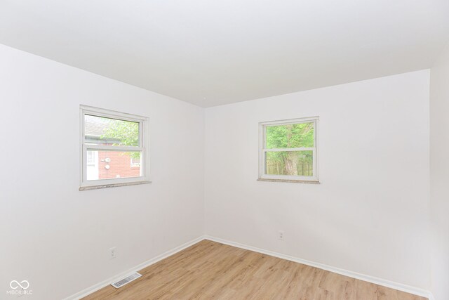 unfurnished room featuring a healthy amount of sunlight and light hardwood / wood-style floors