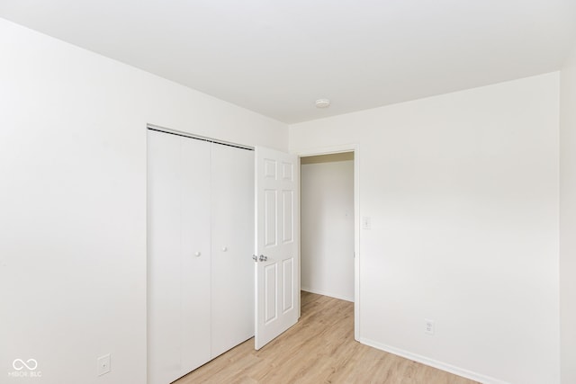 unfurnished bedroom with light hardwood / wood-style floors and a closet