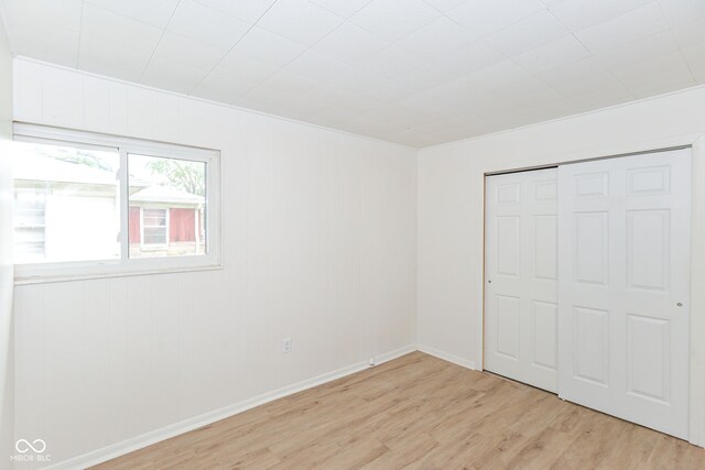 unfurnished bedroom with light wood-type flooring and a closet