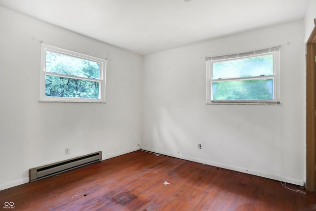 spare room with plenty of natural light, a baseboard heating unit, and hardwood / wood-style flooring