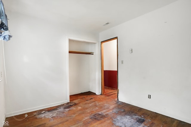 unfurnished bedroom featuring hardwood / wood-style floors and a closet