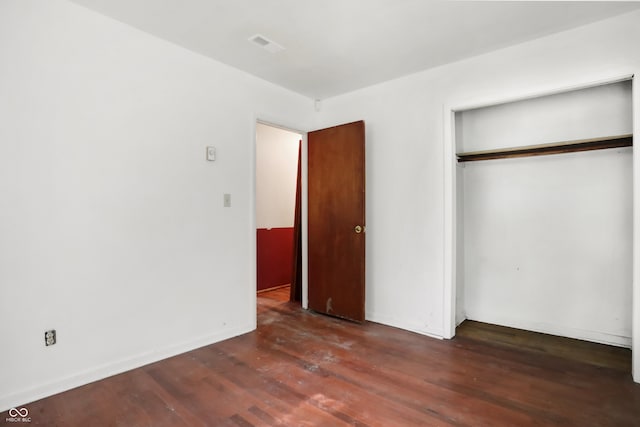 unfurnished bedroom featuring a closet and hardwood / wood-style floors