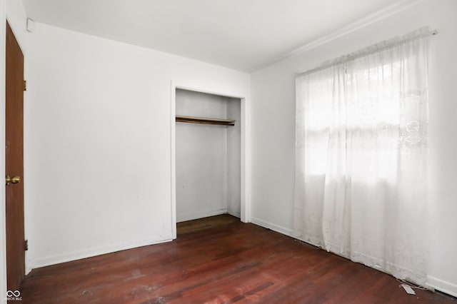 unfurnished bedroom with hardwood / wood-style flooring and a closet