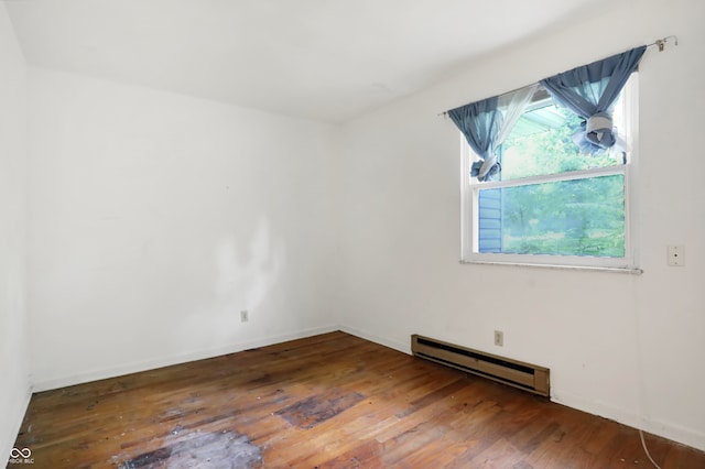 spare room with a baseboard radiator, a healthy amount of sunlight, and hardwood / wood-style floors