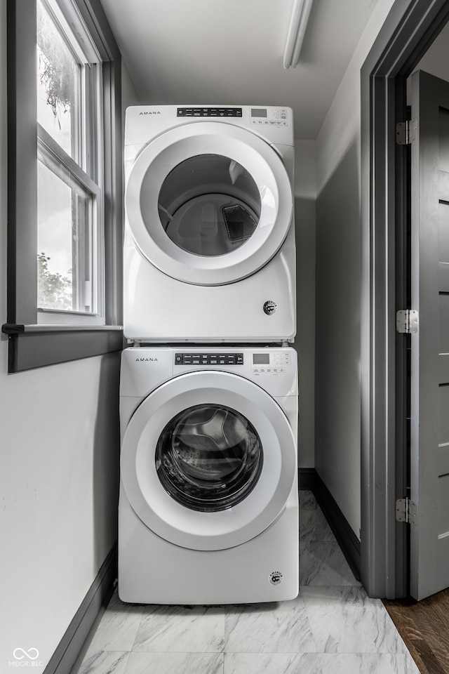 clothes washing area featuring stacked washer and dryer