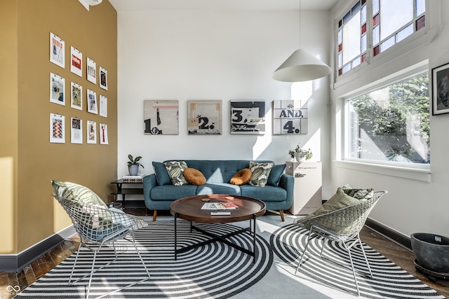 sitting room featuring dark wood-type flooring and a towering ceiling