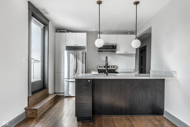 kitchen with sink, white cabinetry, dark hardwood / wood-style floors, pendant lighting, and stainless steel appliances