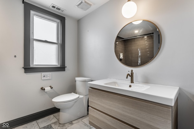 bathroom featuring vanity, walk in shower, and toilet