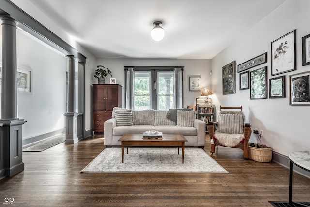 living room featuring decorative columns and dark wood-type flooring