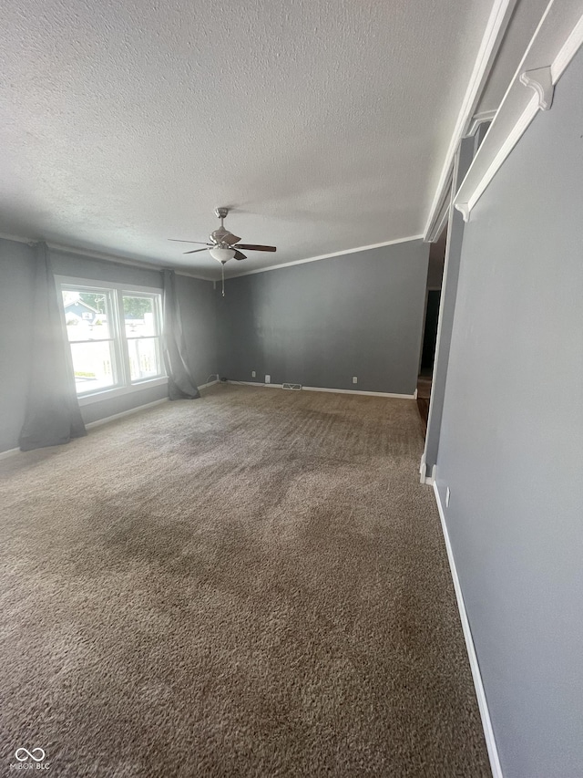 carpeted empty room with ceiling fan and a textured ceiling