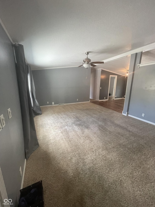 carpeted empty room with ceiling fan and a textured ceiling