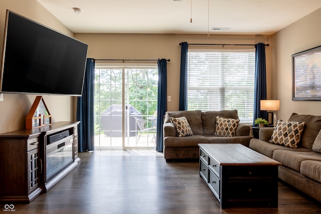 living room featuring a healthy amount of sunlight and dark hardwood / wood-style flooring