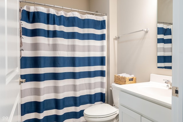 bathroom featuring vanity, curtained shower, and toilet