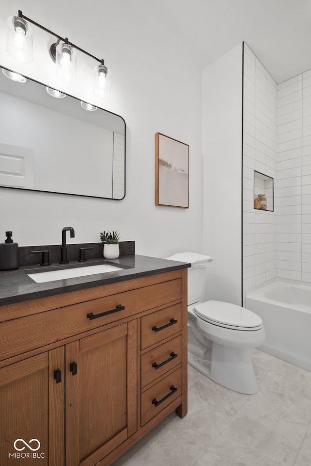 full bathroom with tiled shower / bath, vanity, and toilet