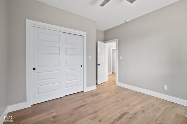 unfurnished bedroom with light hardwood / wood-style floors, a closet, and ceiling fan