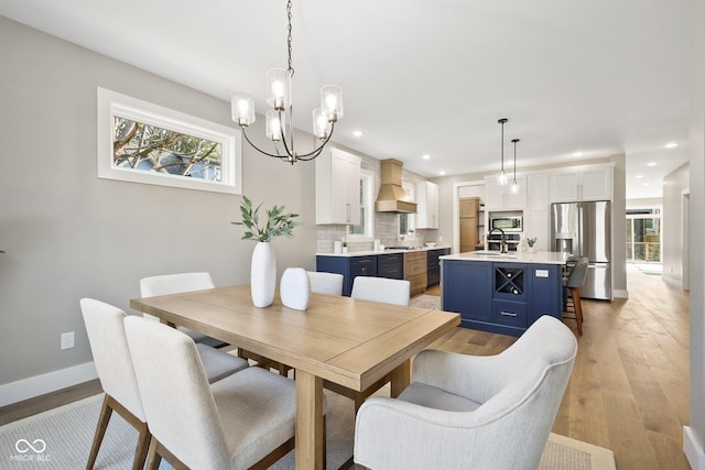 dining space with sink and light wood-type flooring