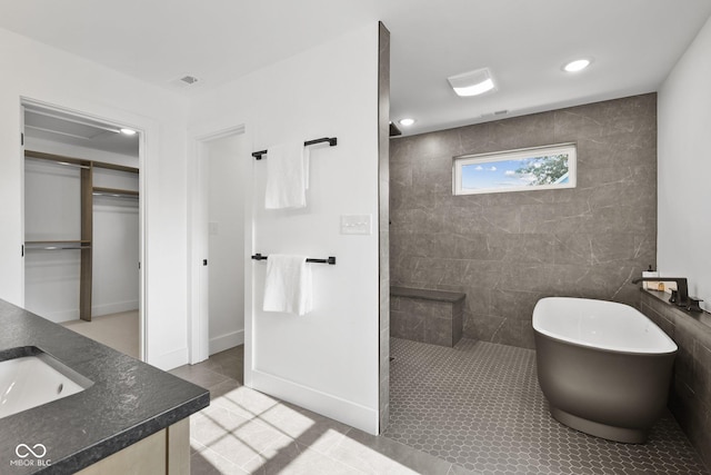 bathroom with tile patterned floors, independent shower and bath, and vanity