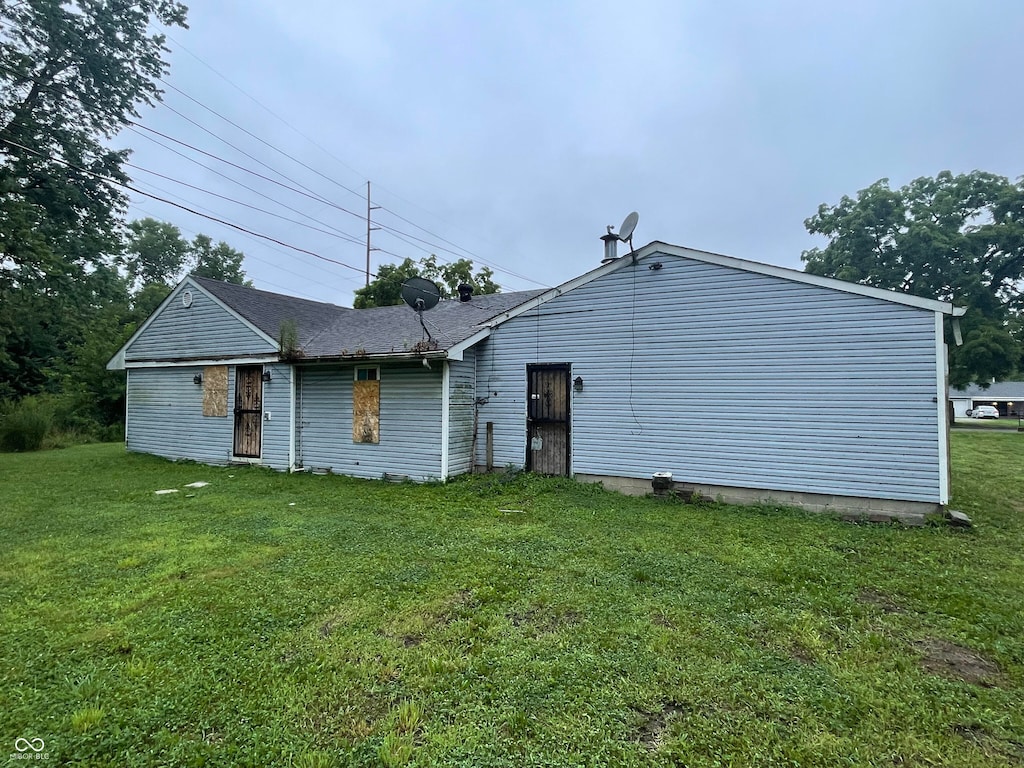 rear view of house featuring a yard