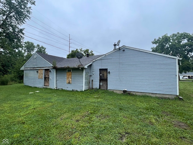 rear view of house featuring a yard