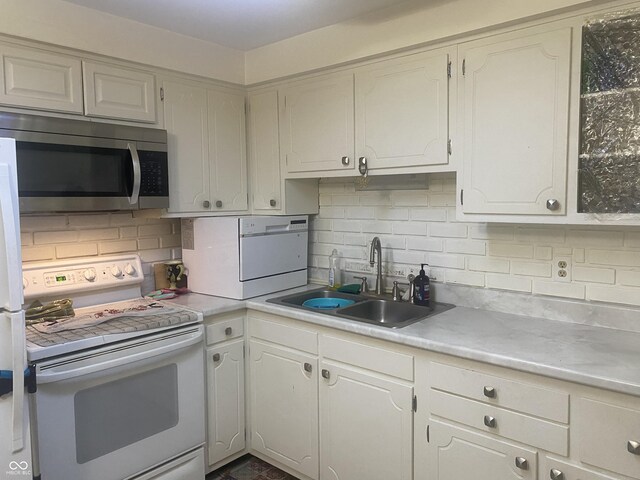 kitchen featuring a sink, white electric stove, stainless steel microwave, backsplash, and washer / clothes dryer