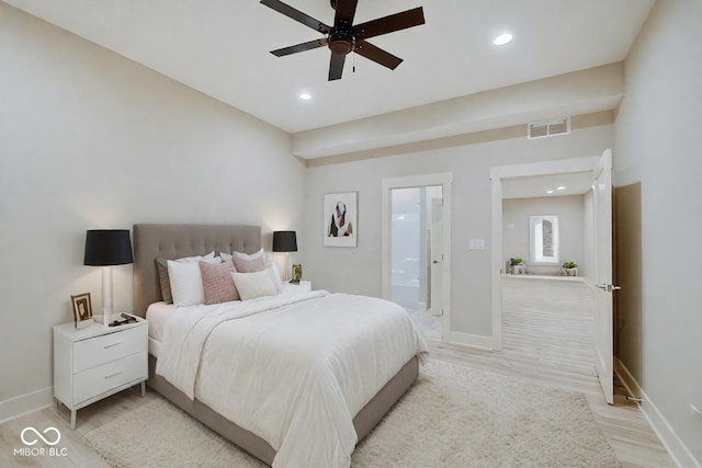 bedroom featuring connected bathroom, light hardwood / wood-style flooring, and ceiling fan