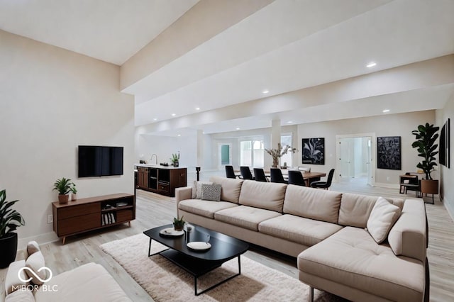 living room with recessed lighting, light wood-style flooring, and baseboards