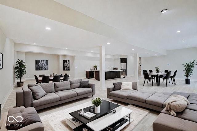 living room with light wood-type flooring, baseboards, and recessed lighting