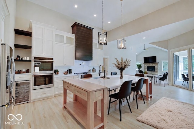 kitchen featuring a fireplace, light hardwood / wood-style flooring, and appliances with stainless steel finishes