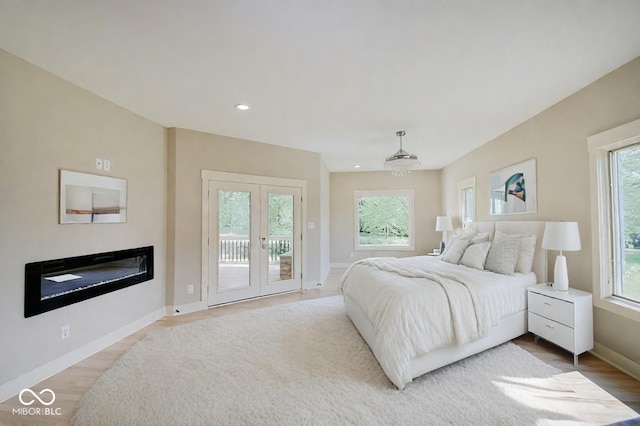 bedroom featuring access to outside, baseboards, wood finished floors, and recessed lighting
