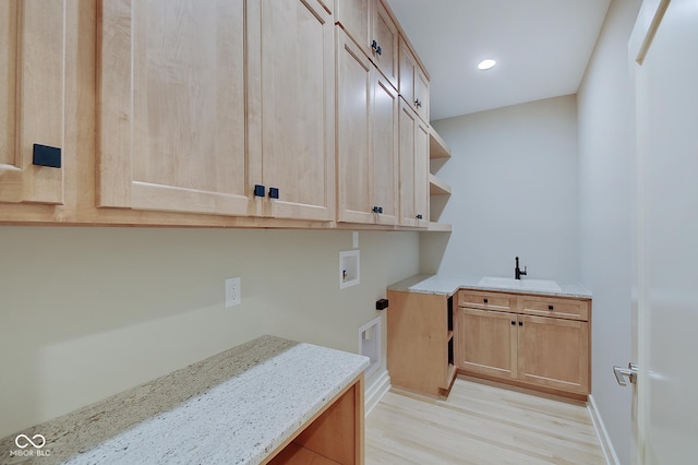 clothes washing area with recessed lighting, washer hookup, a sink, light wood-style floors, and cabinet space