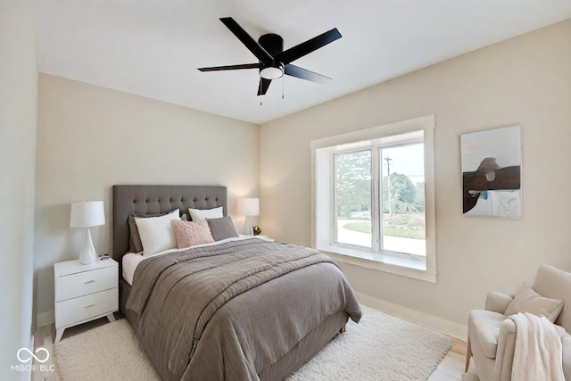 bedroom with a ceiling fan and baseboards