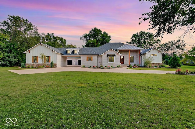 modern inspired farmhouse with a garage and a lawn