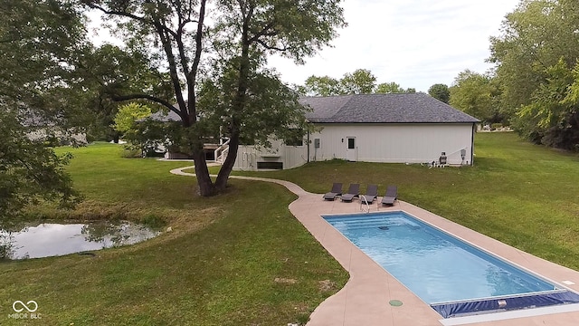 pool featuring a yard, a patio, and a water view