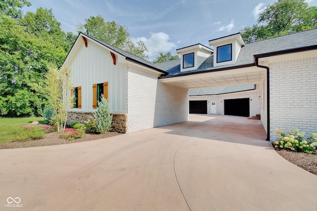 view of side of home with a garage, concrete driveway, and brick siding