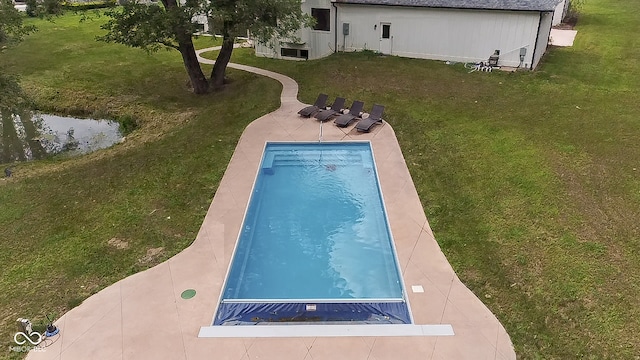 view of pool with a lawn