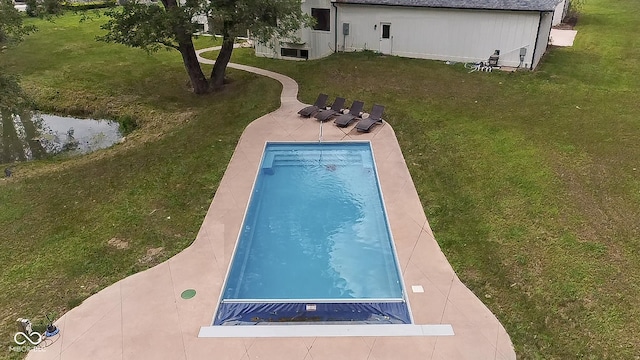 outdoor pool featuring a patio area and a lawn
