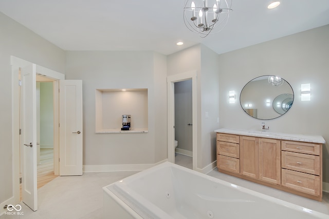 bathroom with hardwood / wood-style floors, a washtub, toilet, vanity, and a notable chandelier