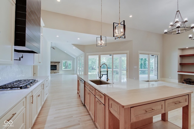 kitchen with a sink, light brown cabinets, open floor plan, and light countertops
