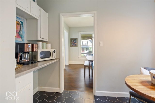 kitchen featuring white cabinetry and dark hardwood / wood-style floors