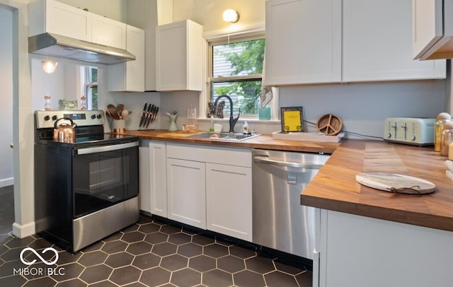 kitchen with wooden counters, sink, appliances with stainless steel finishes, and white cabinets